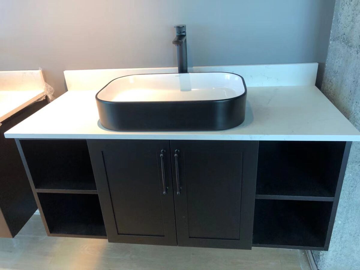 Modern bathroom vanity with black sink and storage cabinets.