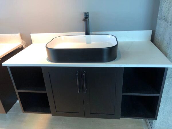 Modern bathroom vanity with black sink and storage cabinets.