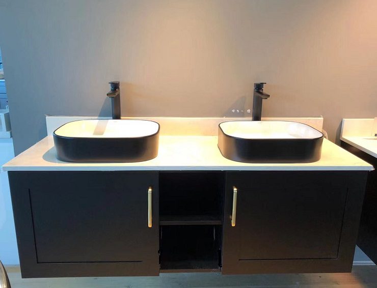 Modern double sink vanity with black cabinets and white countertops.