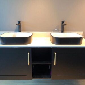 Modern bathroom with double sinks and black cabinetry.