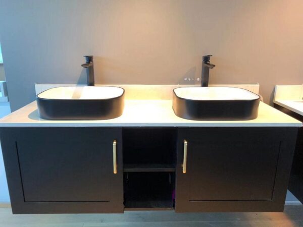 Modern bathroom with double sinks and black cabinetry.