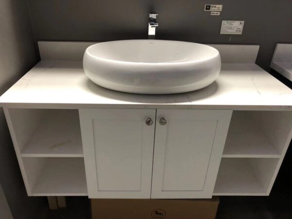 White bathroom vanity with round basin and storage shelves.