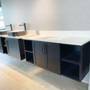 Modern kitchen with black cabinets and dual sinks.