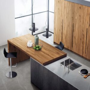 Modern kitchen with wooden table, black stools, and sleek countertops.