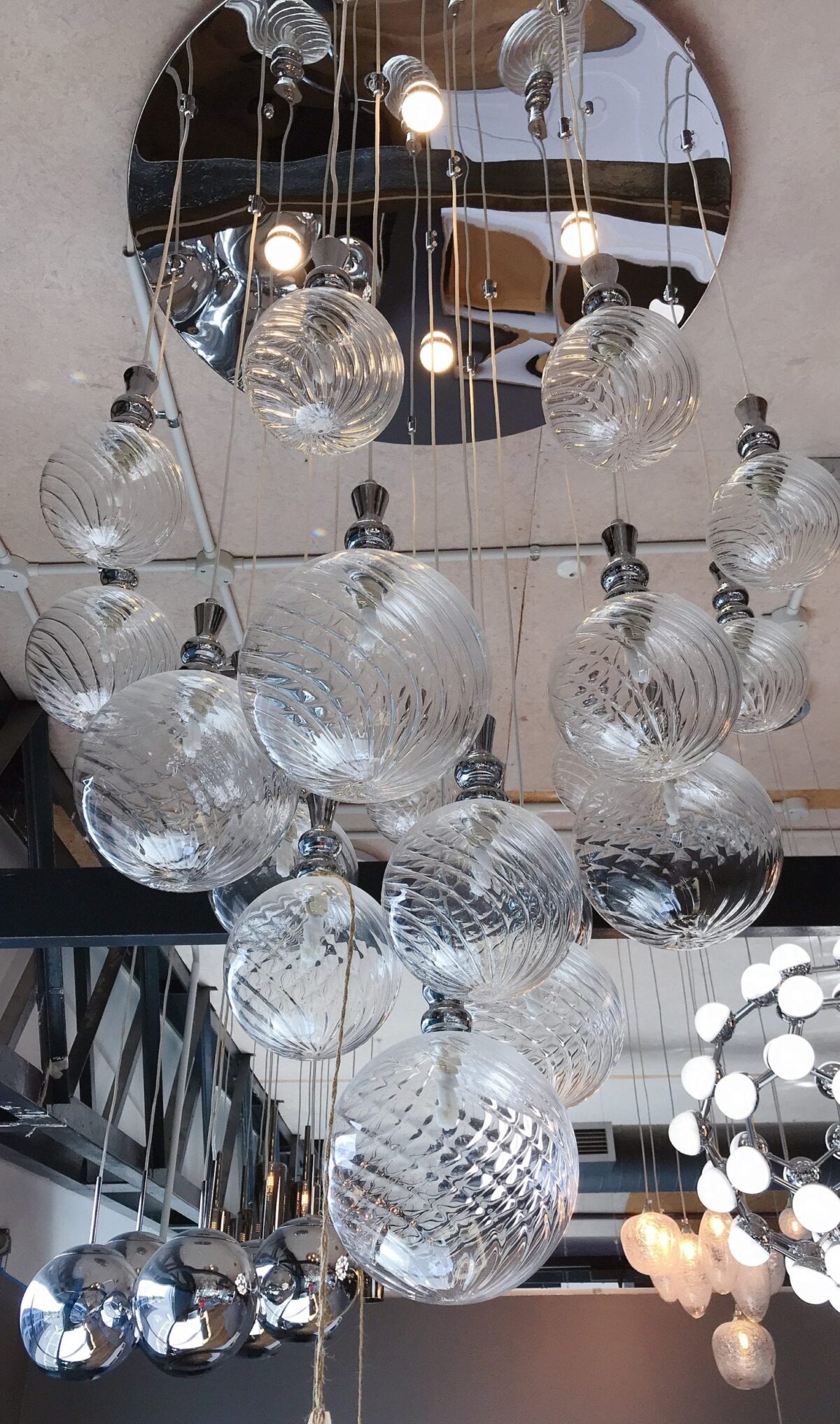 Hanging glass pendant lights in modern kitchen showroom.