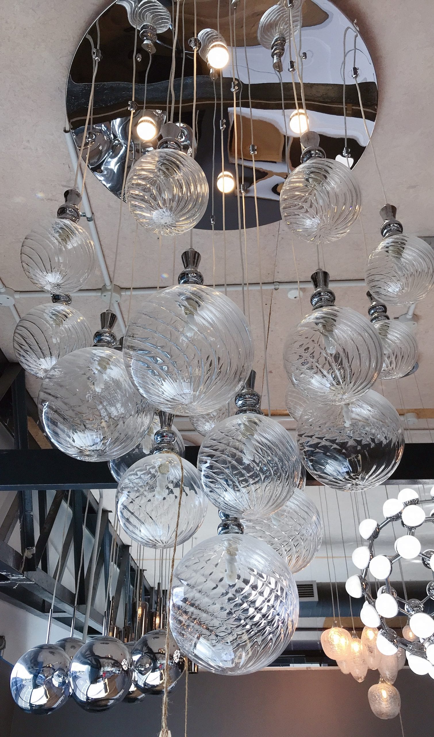 Hanging glass pendant lights in modern kitchen showroom.