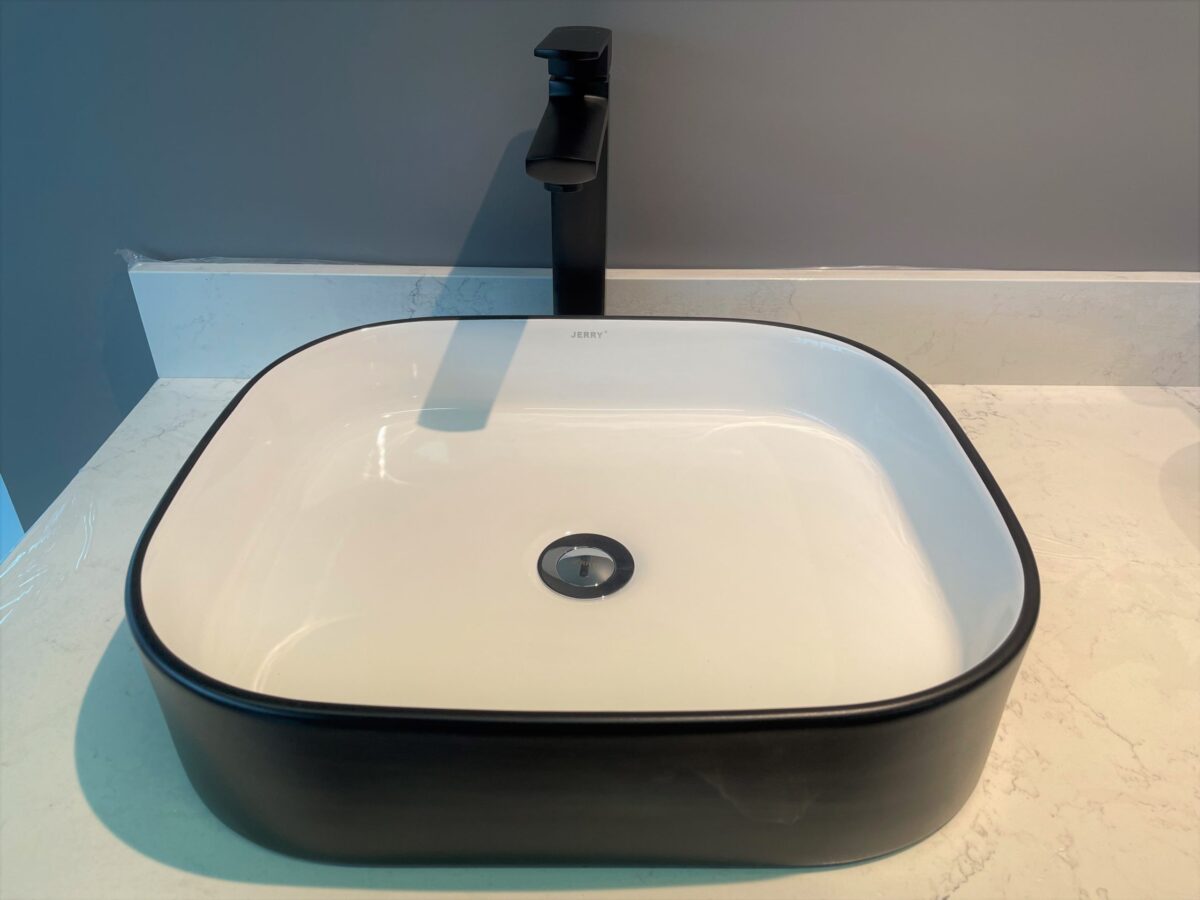 Modern black and white bathroom sink with sleek faucet.