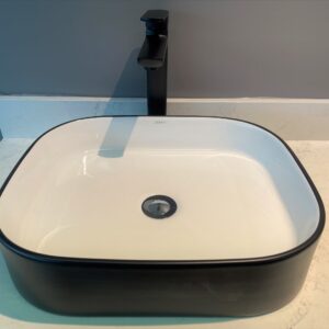 Modern black and white bathroom sink with sleek faucet.