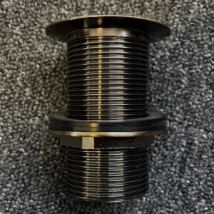 Bronze pop-up waste fitting on textured surface.