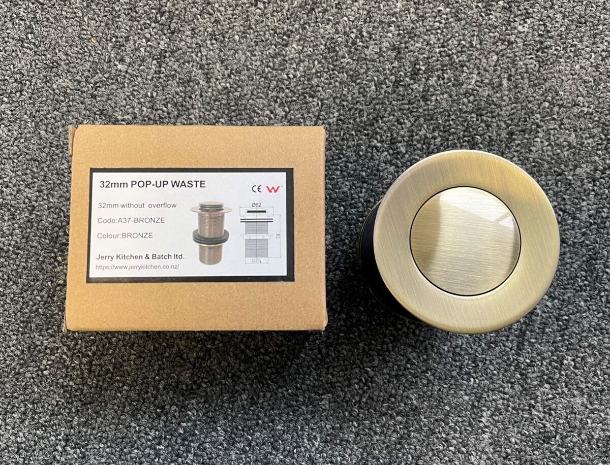 Bronze 32mm pop-up waste with packaging on carpet.