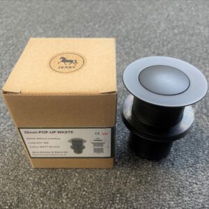 32mm pop-up waste in matte black with packaging on a gray surface.