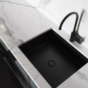 Modern kitchen with black sink and marble countertop.