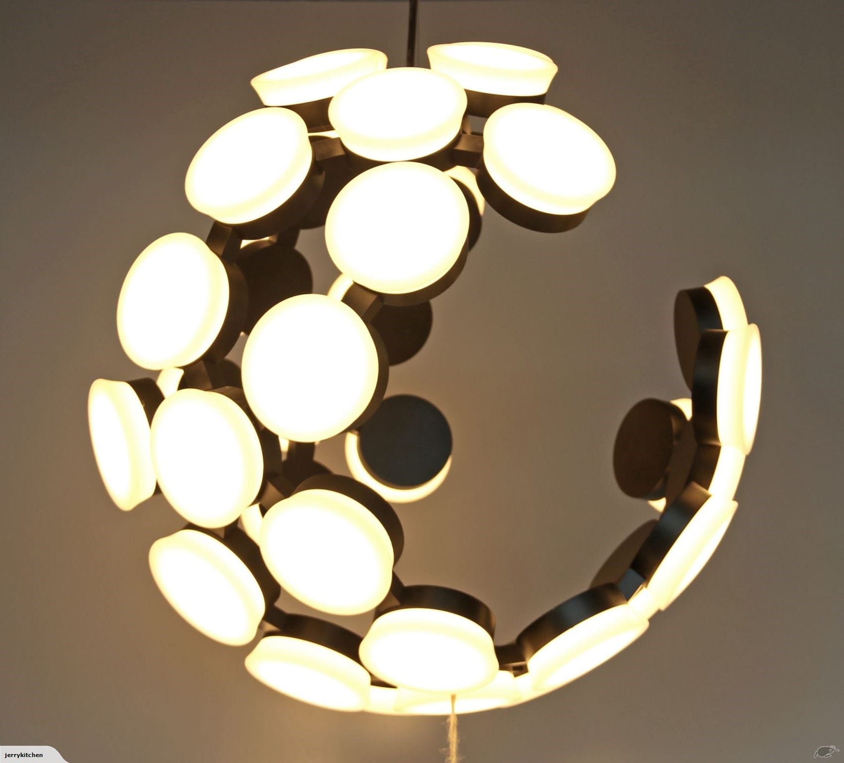 Modern circular chandelier with glowing white lights.