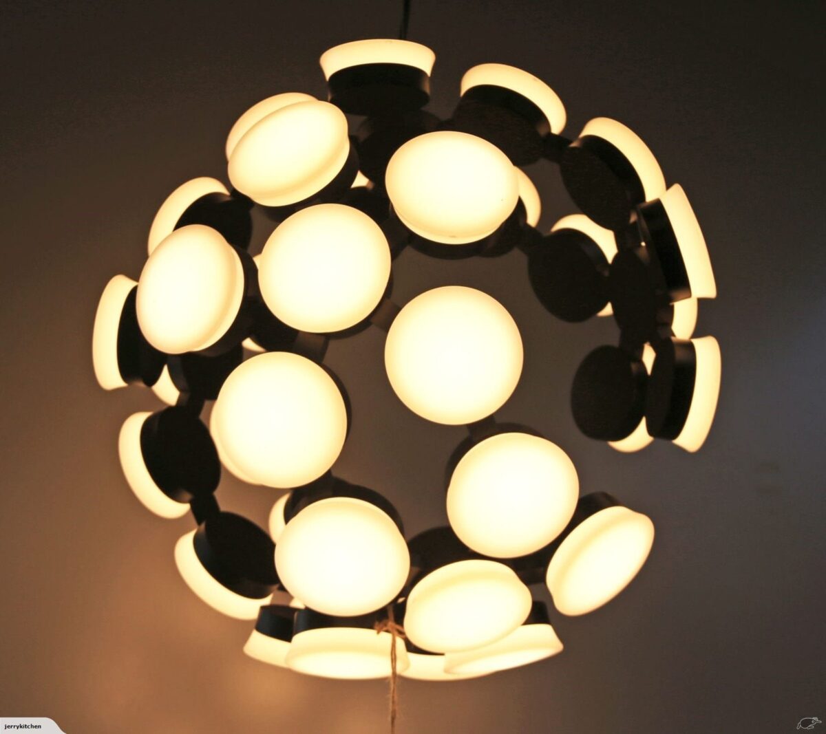 Modern spherical ceiling light with glowing circular bulbs.