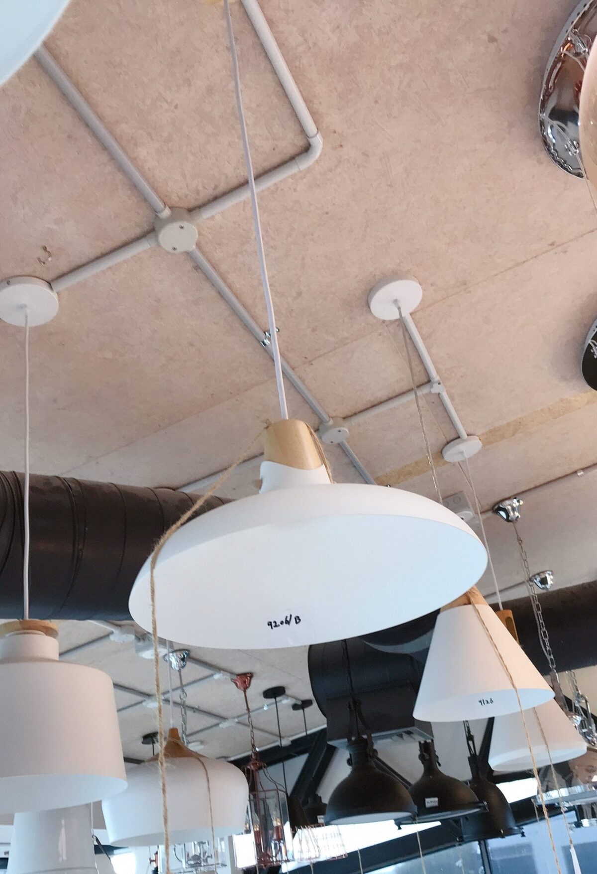 Hanging white pendant lights in a modern kitchen showroom.