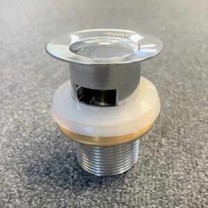 Chrome solid brass pop-up waste with overflow on gray surface.