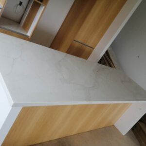 Marble kitchen countertop with wooden cabinets.