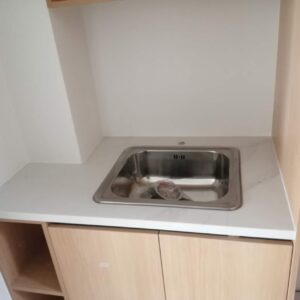 Modern kitchen sink with Calacatta Belleza countertop and wooden cabinets.