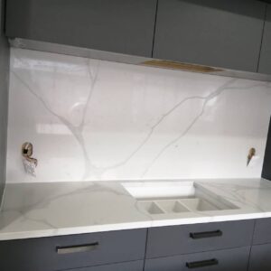Calacatta Sky Quartz countertop and backsplash in modern kitchen setting.