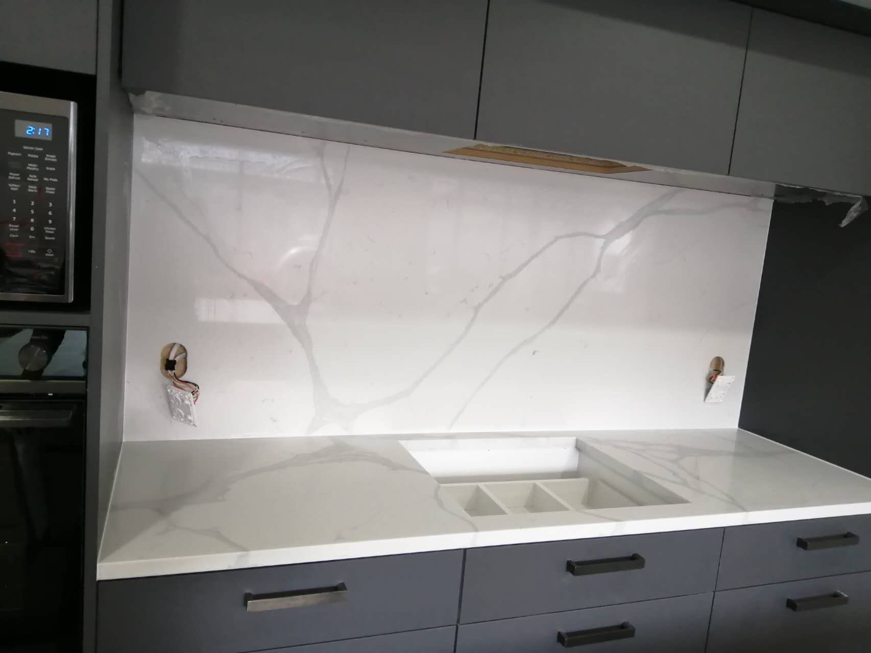 Calacatta Sky Quartz countertop and backsplash in modern kitchen setting.