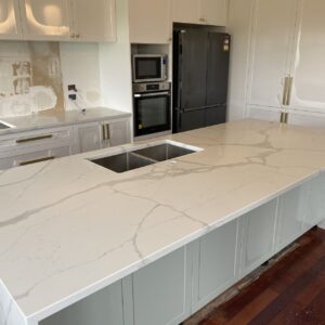 Calacatta Sky Quartz kitchen countertop with sink, surrounded by white cabinets.