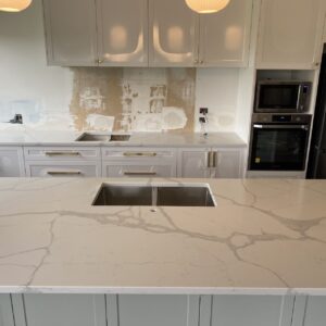 Modern kitchen with Calacatta Sky Quartz countertop and white cabinets.