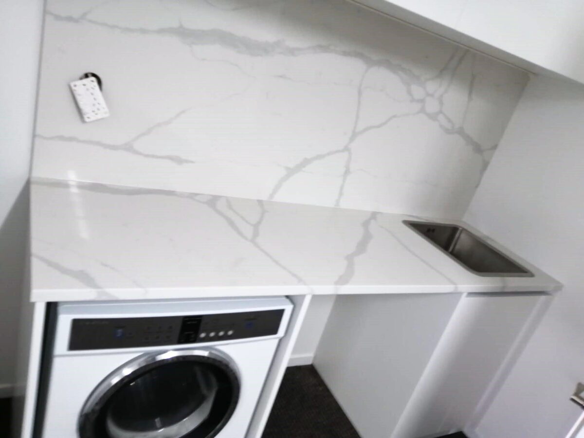 Laundry room with Calacatta Sky Quartz countertop and backsplash.