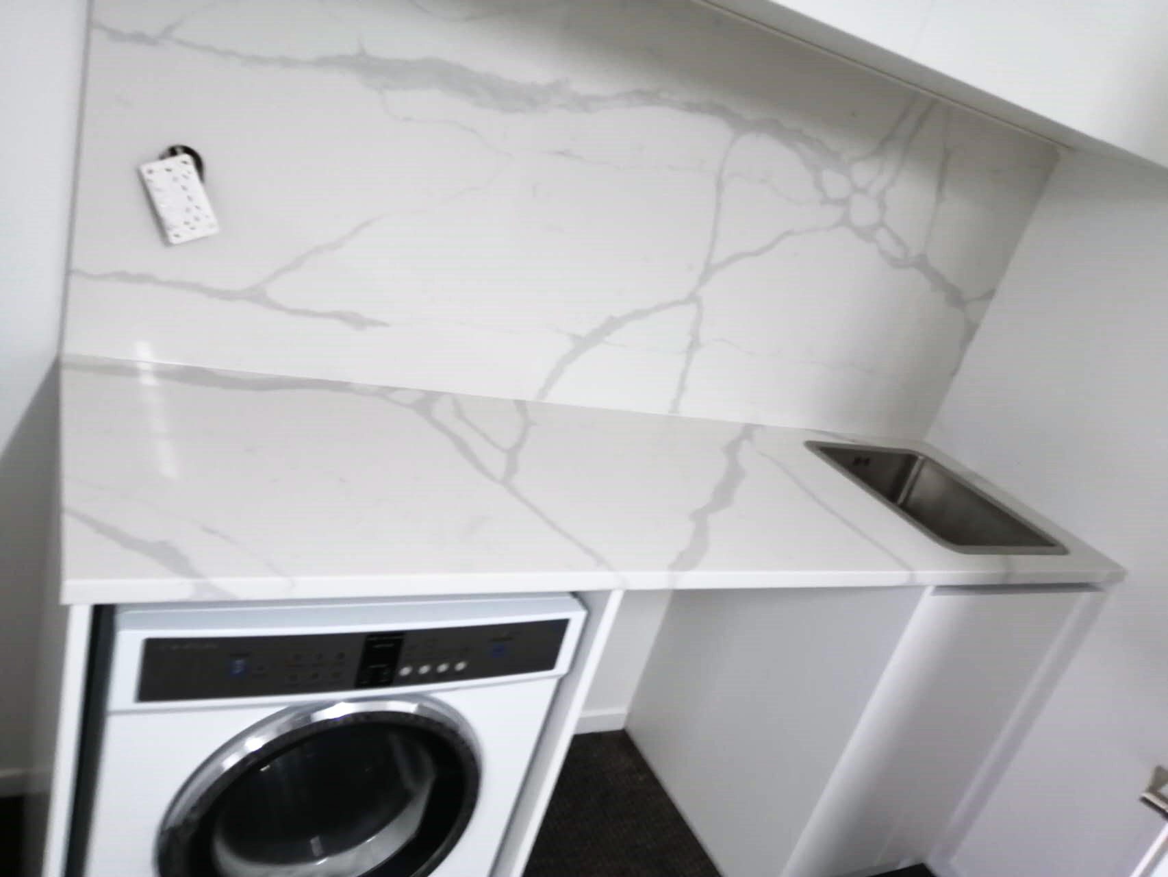 Laundry room with Calacatta Sky Quartz countertop and backsplash.