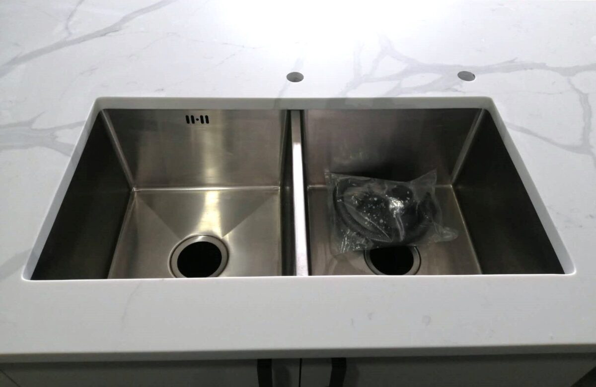 Double stainless steel sink on Calacatta Sky Quartz countertop.