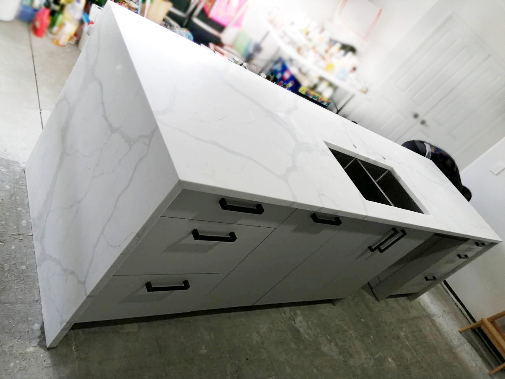 Calacatta Sky Quartz kitchen island with sink and drawers.