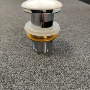 Ceramic pop-up waste on gray surface, Jerry Kitchen product.