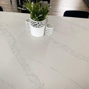 Marble countertop with plant and candle holders.