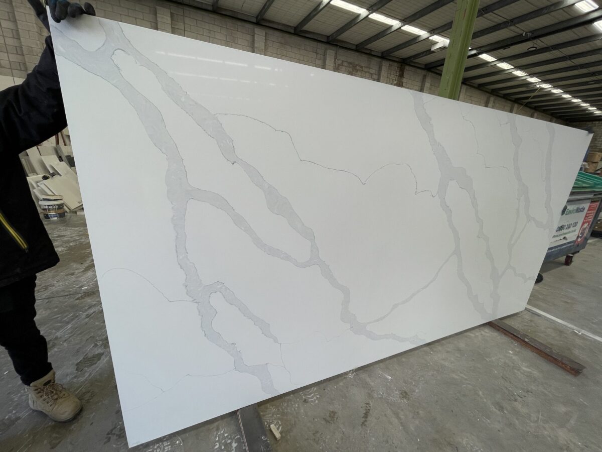 White marble slab with gray veining in a warehouse.