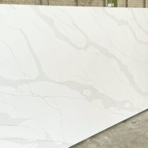 White marble slab with subtle gray veining in a warehouse setting.