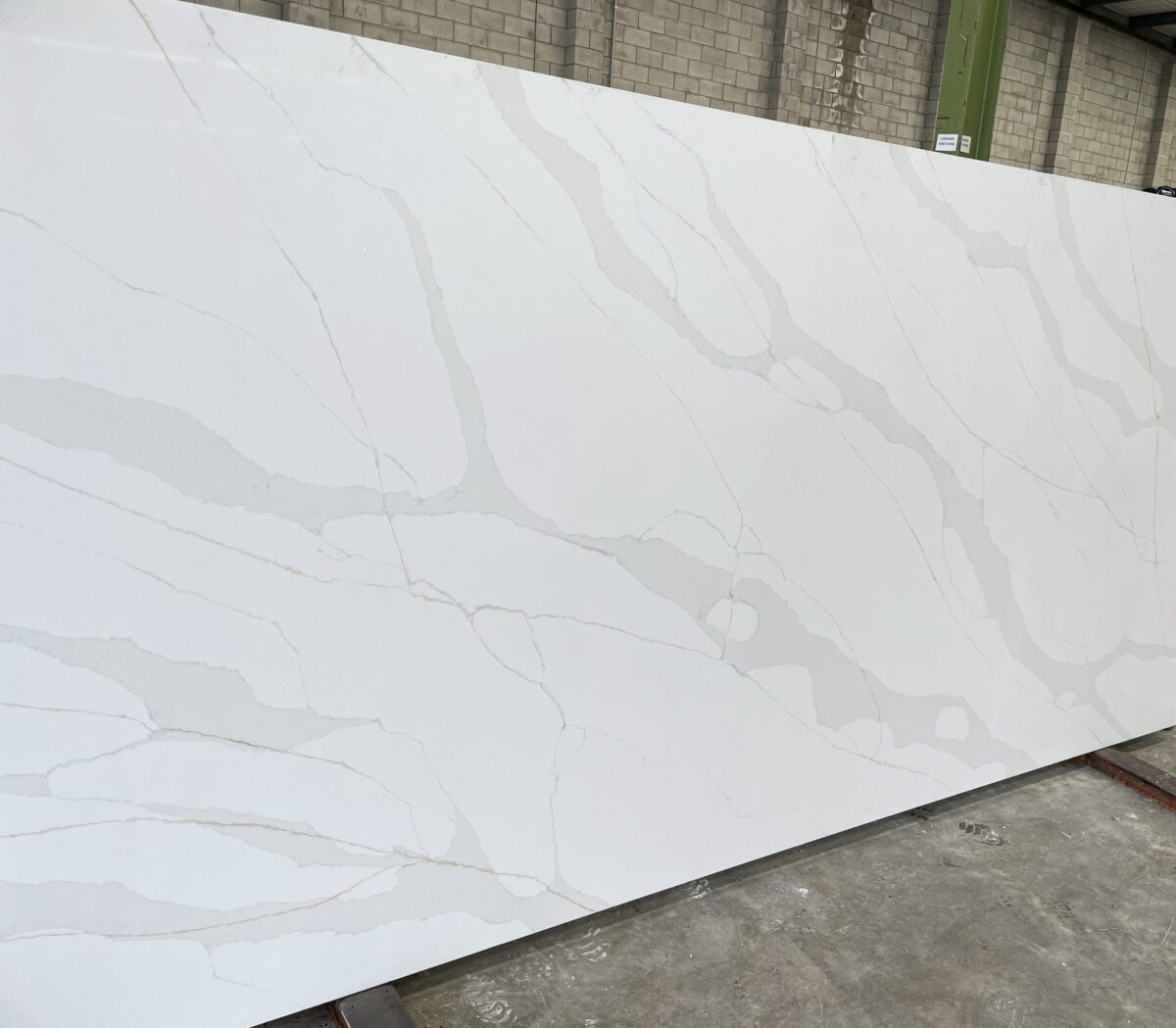 White marble slab with gray veining in a warehouse.