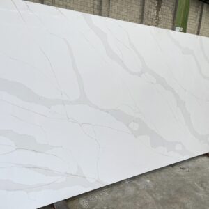 White marble slab with gray veining in a warehouse.
