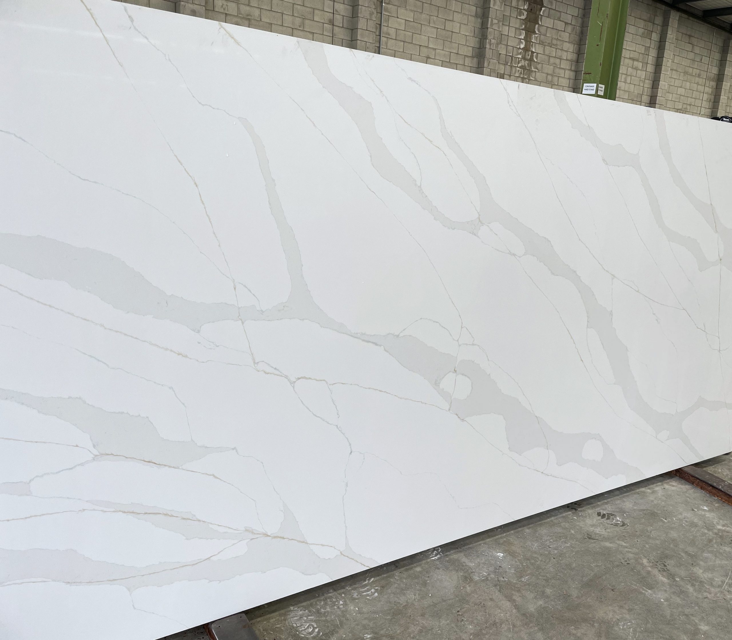 White marble slab with gray veining in a warehouse.