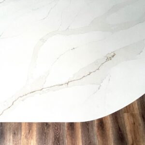 Marble countertop with golden veining on wooden floor.