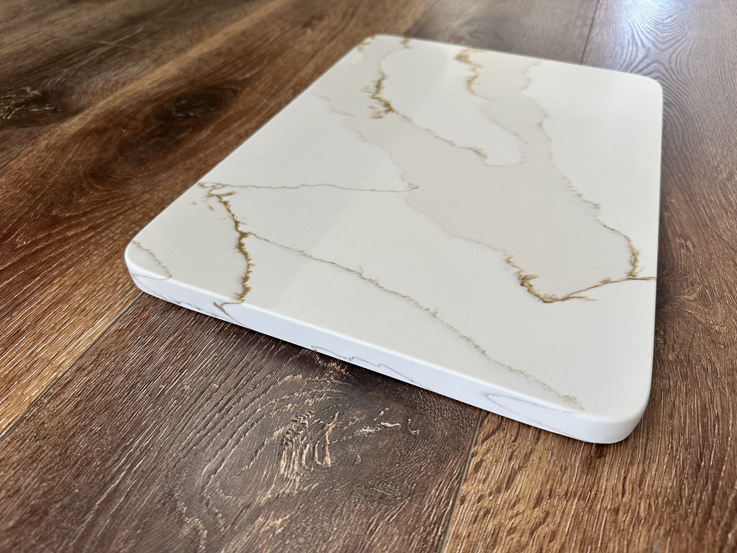 Marble-patterned cutting board on wooden surface.