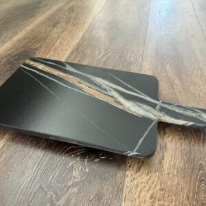 Marble cheese board on wooden floor.