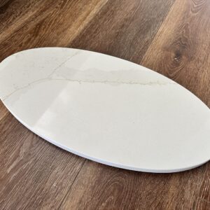 Oval marble serving platter on wooden table.