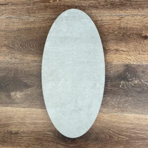 Oval-shaped ceramic plate on wooden floor background.