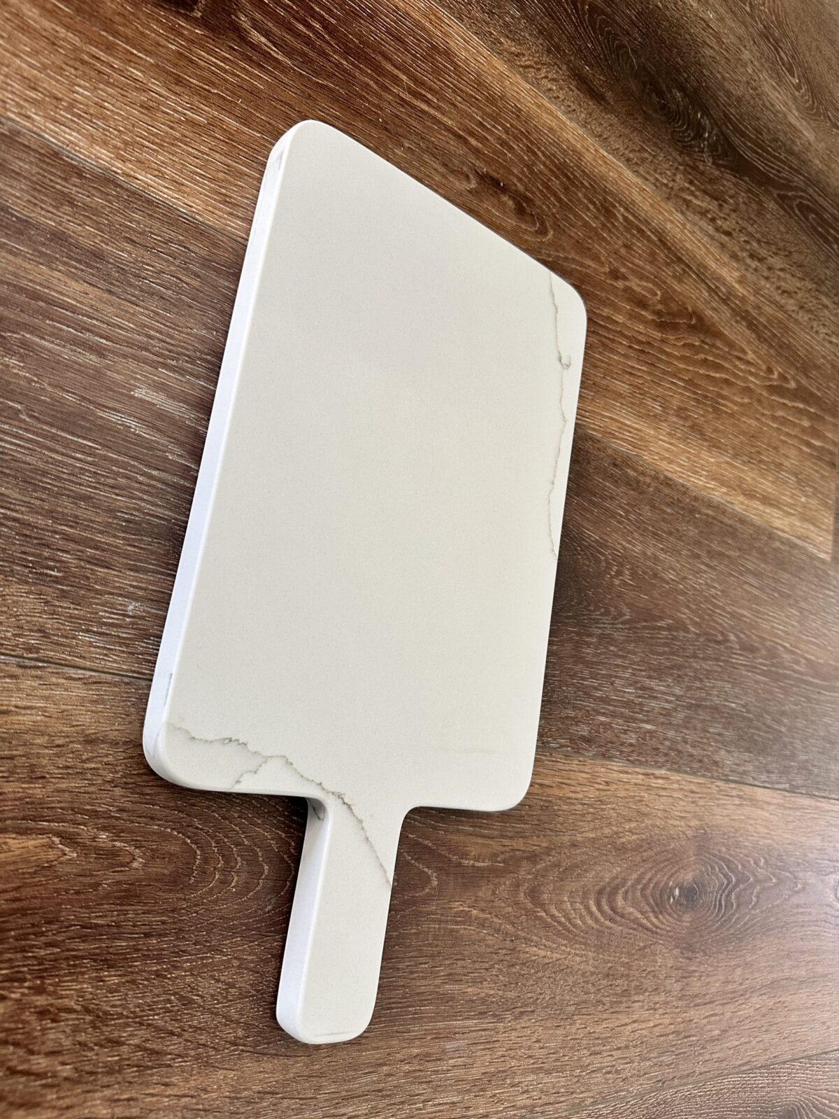 Marble cutting board on wooden surface.