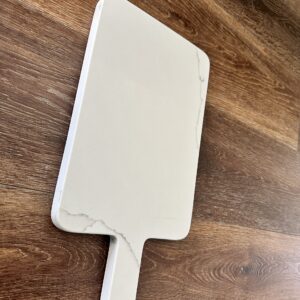 Marble cutting board on wooden surface.