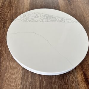 Marble cheese board on wooden table.