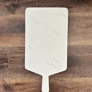 Marble cutting board on wooden surface.
