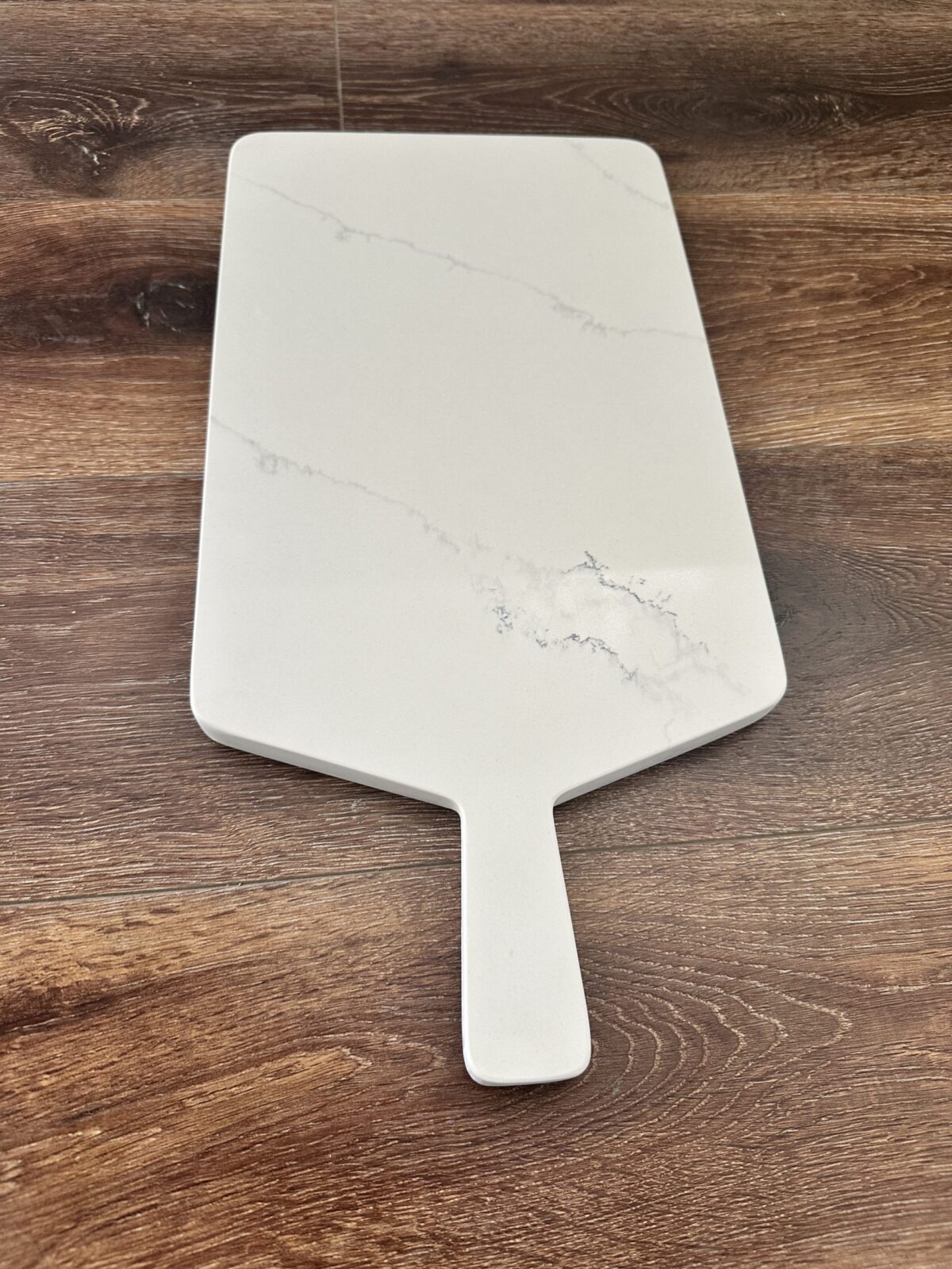 Marble cheese board on wooden table.