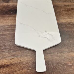 Marble cheese board on wooden table.