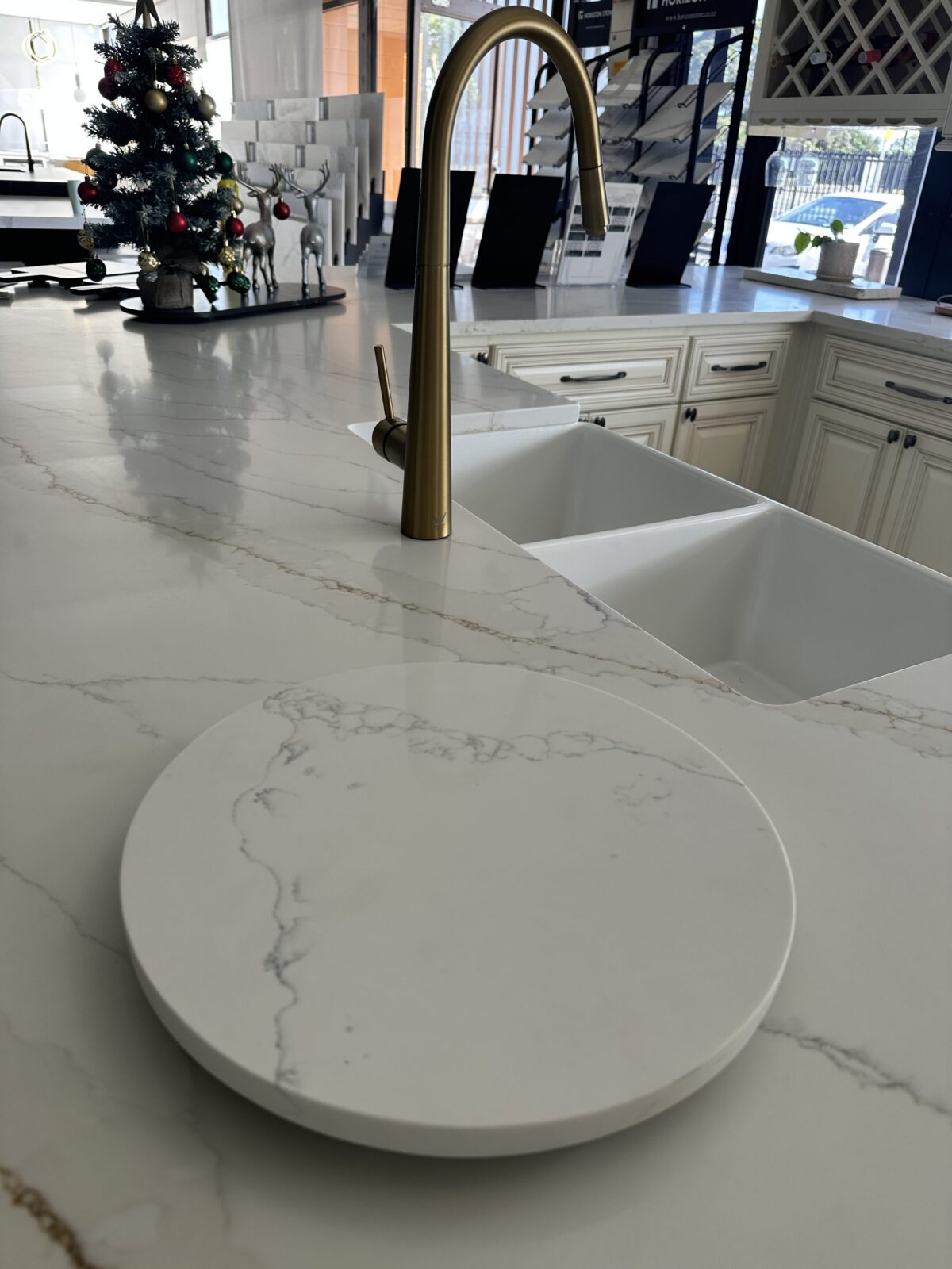 Modern kitchen with marble countertop and brass faucet.