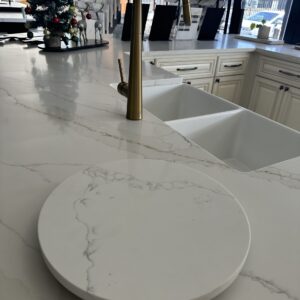 Modern kitchen with marble countertop and brass faucet.